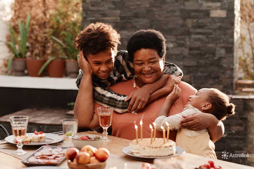 mulher abraçando os filhos em uma mesa com alimentos