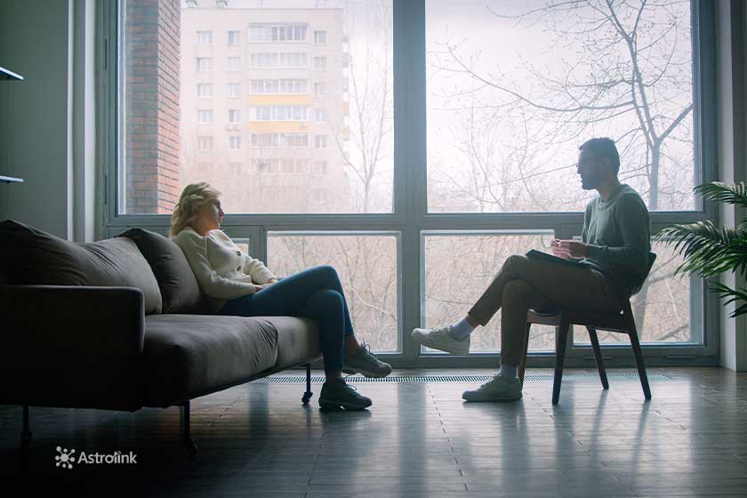 Casal conversando em uma sala em frente à janela